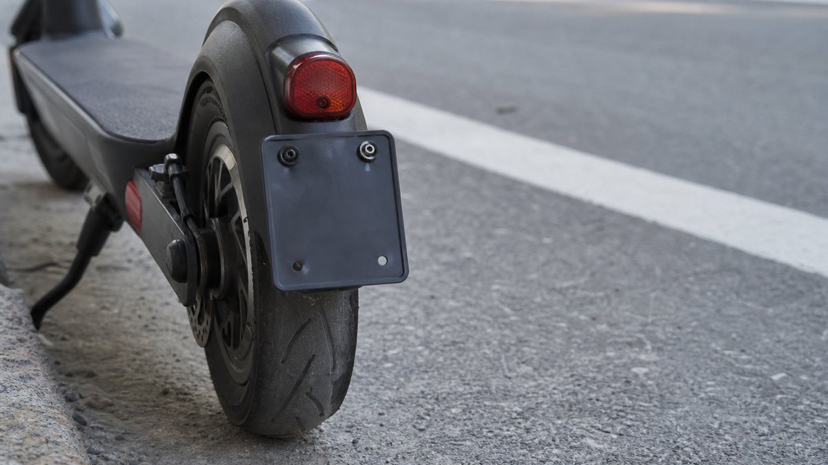 Heck eines E-Scooters mit schwarzem Kennzeichenhalter über dem Hinterrad